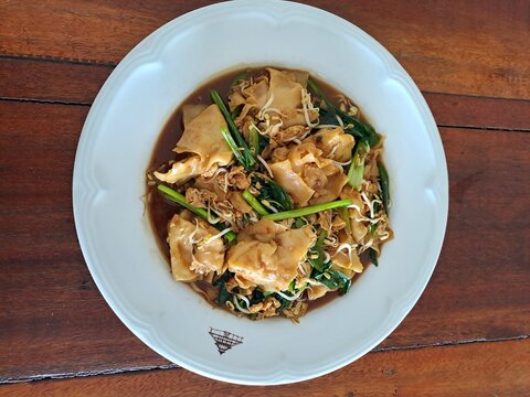Indonesian Bakso Meatball Noodle Soup in White Bowl on Wooden Table