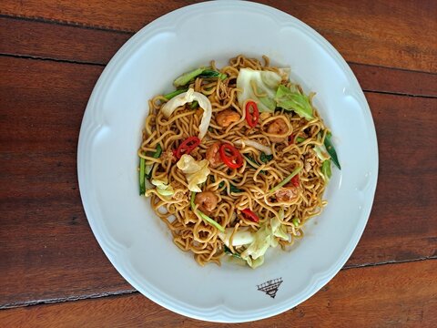 Indonesian Bakso Meatball Noodle Soup in White Bowl on Wooden Table