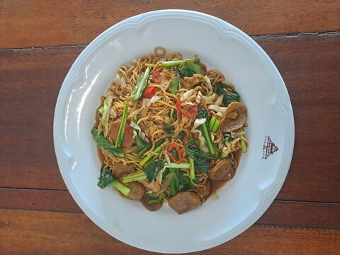 Indonesian Bakso Meatball Noodle Soup in White Bowl on Wooden Table