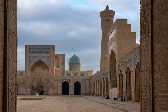 The dome of the Miri Arab Madrasah building and the Kalyan Minaret from the courtyard of the Kalyan Mosque on a sunny day, Bukhara, Uzbekistan