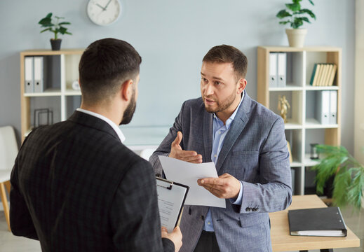 Dissatisfied business people colleagues disputing having disagreement at workplace. Displeased coworkers arguing having conflict standing in office discussing contract. Business conflict concept.