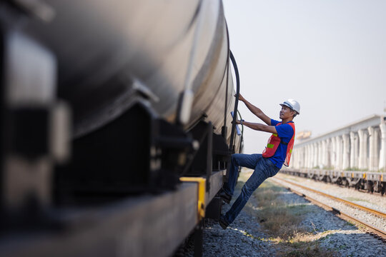 Railway Worker Climbing Freight Tanker for Safety Inspection
