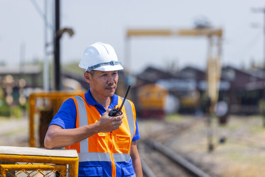 Railway Worker Using Radio Communication at Train Station