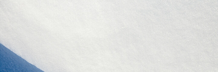 Beautiful winter background with snowy ground. Natural snow texture. Wind sculpted patterns on snow surface. Wide panoramic texture for background and design. Closeup top view with copy space. © Andrei Stepanov