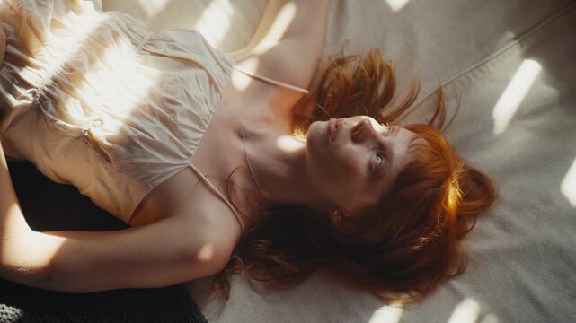 Beautiful redhead woman relaxing in morning sunlight