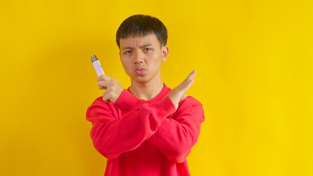 Portrait of Male Teenager Rejection Gesture Toward an E-Cigarette, Promoting Healthy.