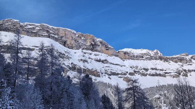 Small avalanche falling down the side of the mountain in winter