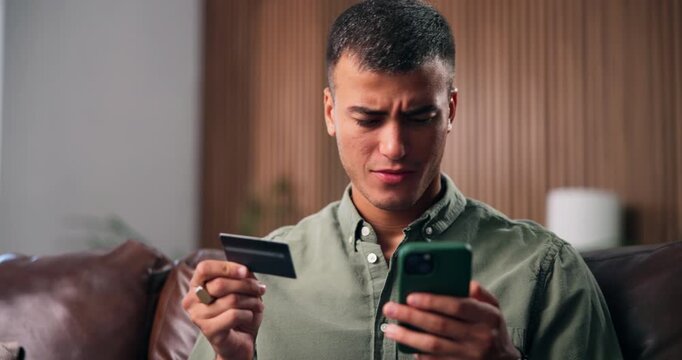 Mobile, credit card and confused man in home with payment fail, low balance or banking error. Phone, debit and person on sofa with scam, online shopping glitch or checkout problem for financial fraud