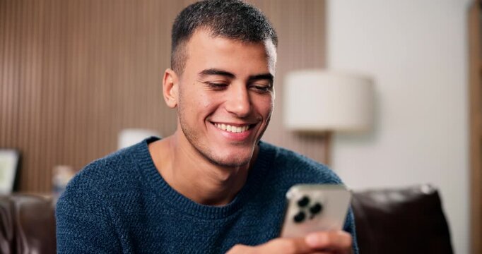 Texting, happy or man on couch with phone, digital conversation or checking notification on dating app. Smile, typing or person in house with tech, connection or romance match on online platform.