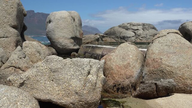 Waves washing over the tidal pool by huge beach boulders