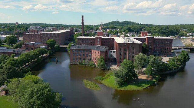 Slow rising drone shot of the historic mill in downtown Dover, NH, USA.It rveals the rest of the city on a warm, bright summer day.