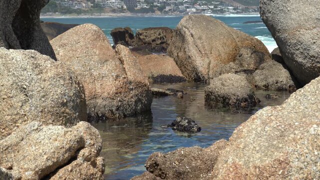 Tidal pool huge granite beach boulders along a rocky coastline