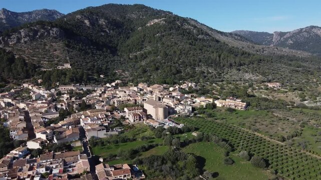 Aerial approach to the village of Caimari, with the Tramuntana mountain range in the background. Mallorca, Spain.