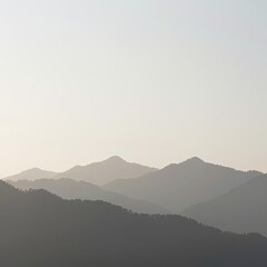 Obraz premium Layered misty mountain range silhouette, soft pastel sky, panoramic landscape, natural beauty
