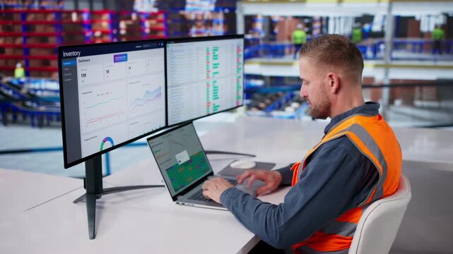 Warehouse Manager Reviews Inventory Report Using Computer Software