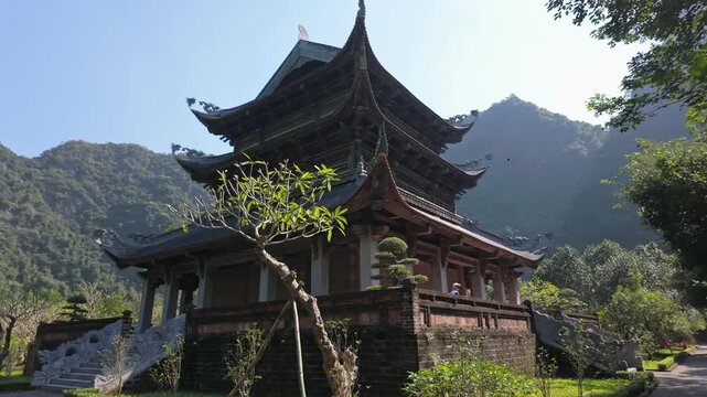 A scenic view of a Pagoda in Trang An, Ninh Binh, Vietnam. The pagoda's architecture and serene setting attract tourists and locals for spiritual reflection.