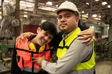 Fototapeta premium A worker wearing protective gear supports an injured coworker, showing signs of pain, emphasizing the importance of workplace safety and rapid response to accidents.