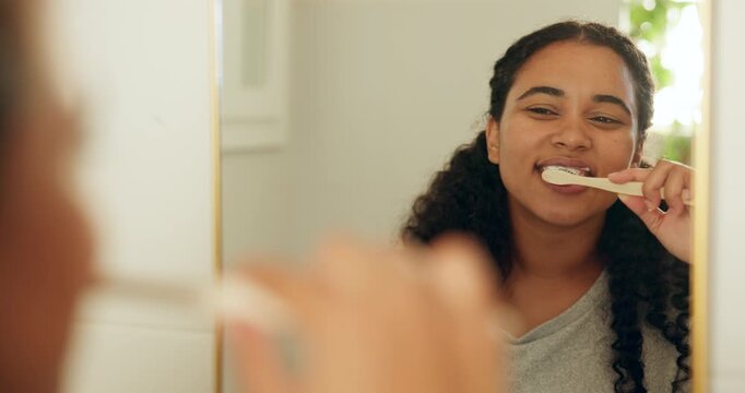 Brushing teeth, mirror and woman in bathroom, dental hygiene and morning routine for self care. Oral health, reflection and person in home, toothpaste and cleaning mouth for wellness or remove plaque