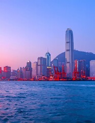 Obraz premium A serene cityscape at dusk with a large body of water (1)
