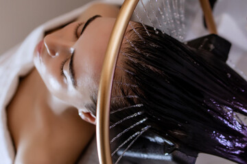 Close-up of a woman receiving a head massage during a Japanese head spa treatment with water...