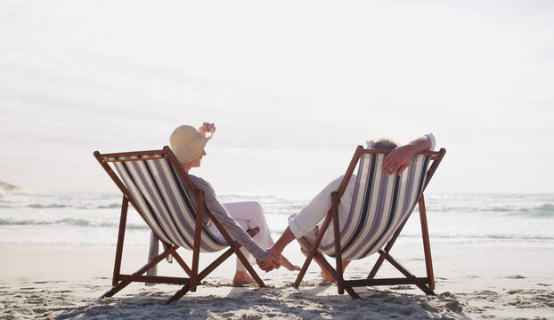 Old couple, relax and chairs at beach on vacation with bonding, love and connection in summer. Senior people, partner and outdoor by ocean, relationship and space on seaside holiday in retirement