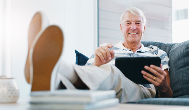 Portrait, relax and tablet with old man on sofa in home living room for me time, retirement or wellness. App, comfortable and digital with happy senior in apartment for social media browsing