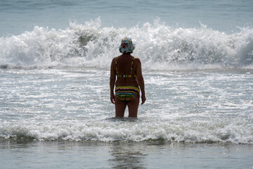People relaxing near the sea on a beach in Hua Hin on a sunny day.