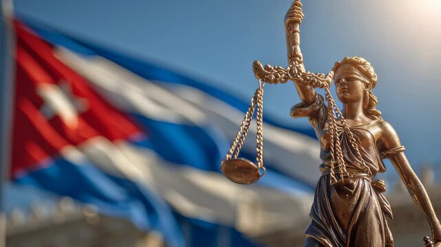 Justice statue stands in front of the Cuban flag during a sunny day in Havana