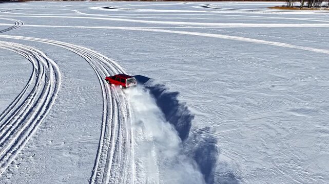 Old Volvo doughnuts, clutch kick revealing blizzard powder, drone following old vehicle