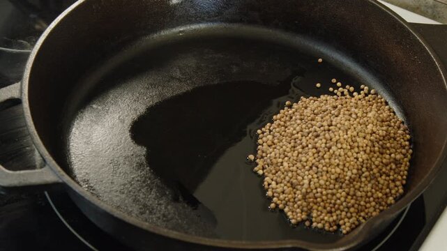 Whole spices added to cast iron pan: coriander, fennel, cumin, pepper