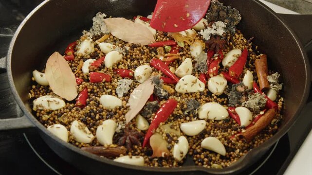Spicy Chettinad masala ingredients toasted in hot cast iron stovetop pan