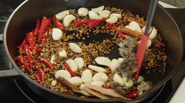 Hot, spicy, aromatic masala ingredients stirred in hot cast iron pan