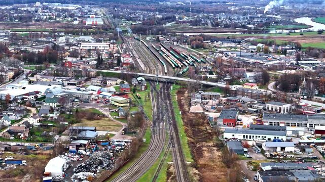 Aerial dolly forward over railway junction and freight train yard cutting through the town of Jelgava Latvia in autumn