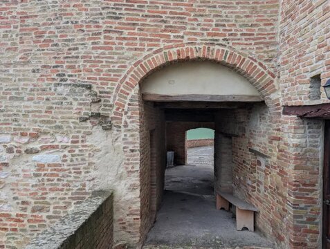 Camminamento sulle mura medievali con vista sulle colline con edifici storici in pietra