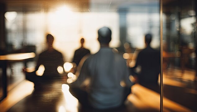 Silhouetted figures meditating in a sunlit, reflective room