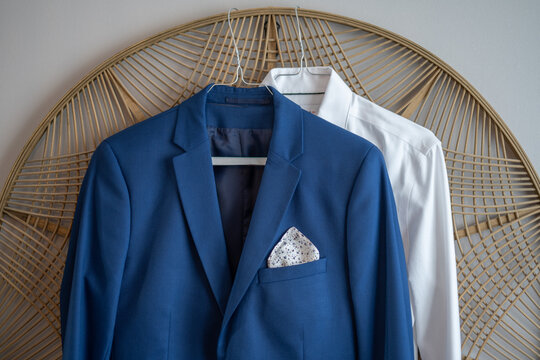 Veste de costume de mari&eacute; bleu sur un fauteuil en rotin