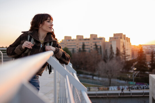 Woman standing near railing under clear sky at sunny day
