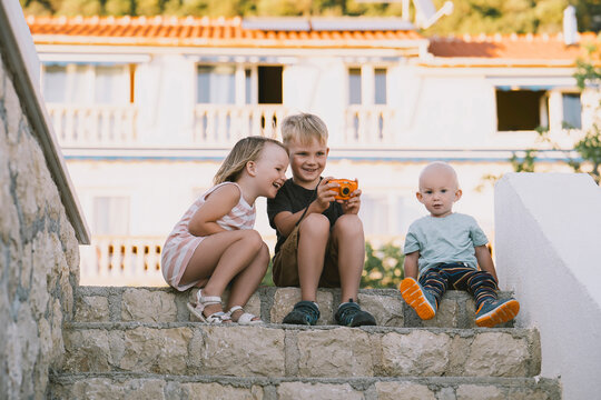Children bonding outdoors taking photos together during summer vacation