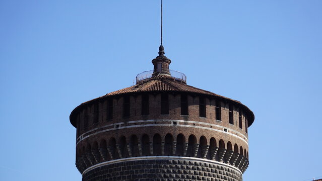 Round Medieval Fortress Tower With Spire Against Blue Sky