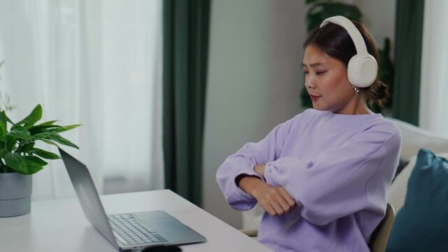 Happy Asian Woman Clicking Send Button and Raising Arms in Success at Home