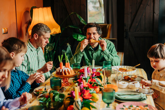 Family enjoying Easter dinner together at home with festive table