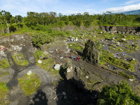 Aerial view of the rugged Woro River's rocky terrain, carved by nature's hand, contrasts sharply with the verdant trees, Klaten Regency, Central Java, Indonesia.
