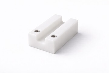 machined acetal conveyor guide block isolated on white with precise industrial geometry and soft diffused studio lighting