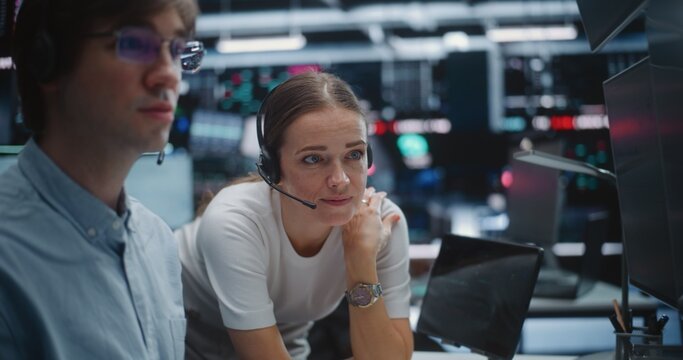 Male and Female Brokers Analyzing Real Time Stock Data Together. Two Professional Investment Experts Collaborate Closely on Trading Floor. Strategy Discussion, Data Driven Decision Making, Teamwork.