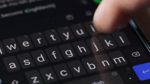 Typing message on smartphone keyboard, close up. sending text message using mobile phone. press touch screen keyboard keys. smart phone, dark mode display. texting online. web communication. send sms