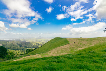 Fototapeta premium Rolling Green Hills Under Bright Blue Sky