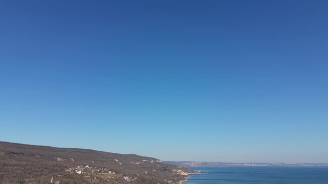 Minimal aerial landscape with clear blue sky and distant hills forming calm natural horizon background.
