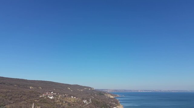 Wide aerial view of clear blue sky above distant hills creating minimal natural landscape background captured from drone.