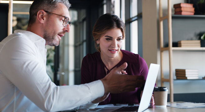 Creative, woman and man with advice on laptop for editorial guidance, story review or feedback. Journalist, lead editor or meeting with tech in newsroom for fact checking, headline idea or teamwork