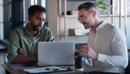 Reading, online and men with laptop, office or advice for article on website, talking and...